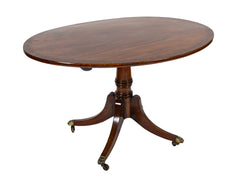 An Oval Regency Triple Banded Tilting Mahogany Breakfast Table