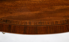 An Oval Regency Triple Banded Tilting Mahogany Breakfast Table