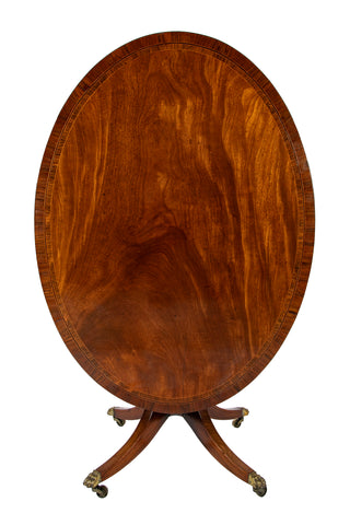 An Oval Regency Triple Banded Tilting Mahogany Breakfast Table